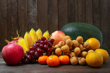 Variety of fruits with vivid color on old wooden background.