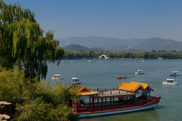 Fototapeta premium South Lake Island Dragon boat ferry with Jade Peak Pagoda and Jade Belt Bridge at Summer Palace Beijing
