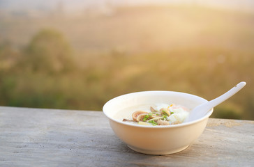 Rice soup or congee in bowl with natural mountain view for eating in morning time 