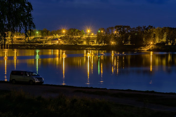 Fototapeta na wymiar Night Landscape with river coast and street lights on the coast line.
