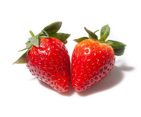 two strawberries lie mirrored to each other, isolated on a white background