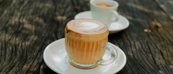 Coffee cup with heart shape art on wooden table