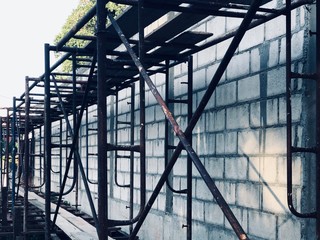 Cement brick wall and scaffolding structure at construction site