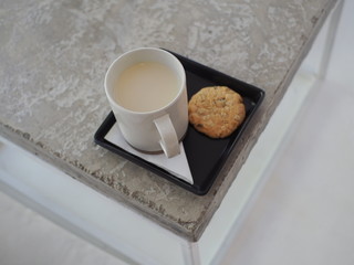 A mug of soy milk with healthy grain cookie.