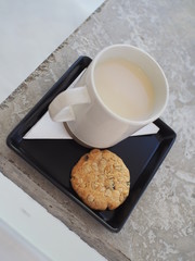 A mug of soy milk with healthy grain cookie.