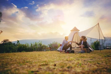 Foto op Aluminium Jonge koppels hebben een goede tijd & 39 s ochtends op kampeertrip met zonsopgang achtergrond. Koppels genieten van kamperen met koffie in de ochtend. © Panumas