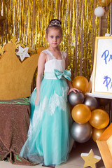 Portrait of girl princess in turquoise dress with diamond diadem