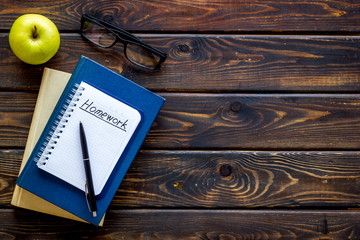 Books for homework on dark wooden student desk top-down copy space