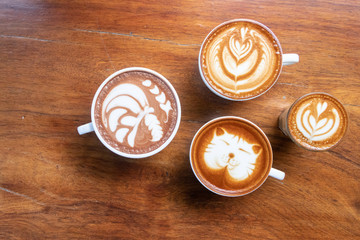 Coffee cup with latte art foam on wood table in coffee shop with copy space.Coffee is one of the...