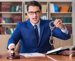 Handsome judge with gavel sitting in courtroom