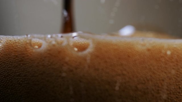 Macro shot of a dark beer being poured into a glass