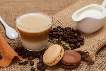 Coffee cappuccino, cream and coffee beans on sackcloth background