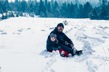 Fototapeta na wymiar Happy father and child having fun together at snowy day