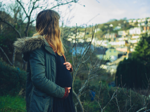 Pregnant woman standing in garden on winter day