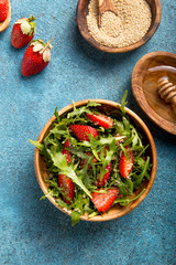 Arugula salad with quinoa on blue concrete table. Dietary food.