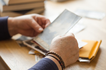 Memory. Eldery woman looking vintage photos.