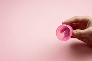 Close-up of young woman hands folding a menstrual cup.