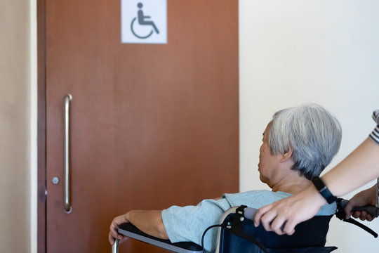 Stressed Asian Senior Woman With Wheelchair Waiting On A Long Time At Front Disabled Toilet,queue Of Disabled Elderly Waiting At Accessible Restroom,female Old Need To Pee,people With A Full Bladder