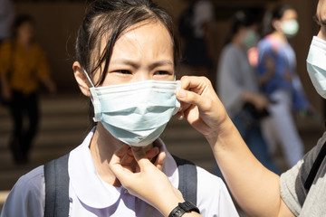 Asian child girl wearing medical mask in public area at risk of disease,people prevent infection from spreading of Coronavirus 2019-nCoV in Wuhan China,protection Influenza,SARS,cold and flu season