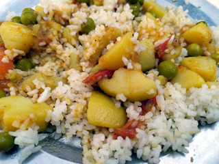some rice and vegetable put in a steel plate on stone background