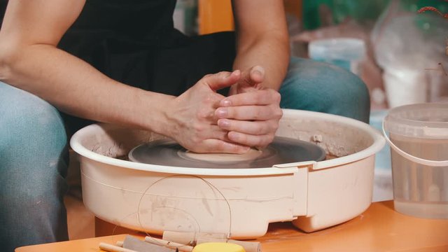 Pottery - the master with wet hands is begining to pull the clay up
