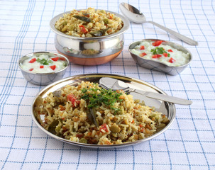 Pongal, a traditional, popular, delicious, and south Indian vegetarian rice dish, and raita made from yogurt, cucumber, and tomato.