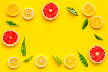 Citrus fruits - lemons, grapefruit slices - on yellow background mockup, frame top-down copy space