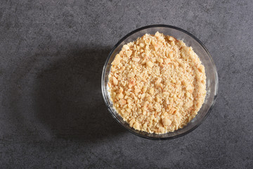 Crushed hazelnut pieces in a glass bowl