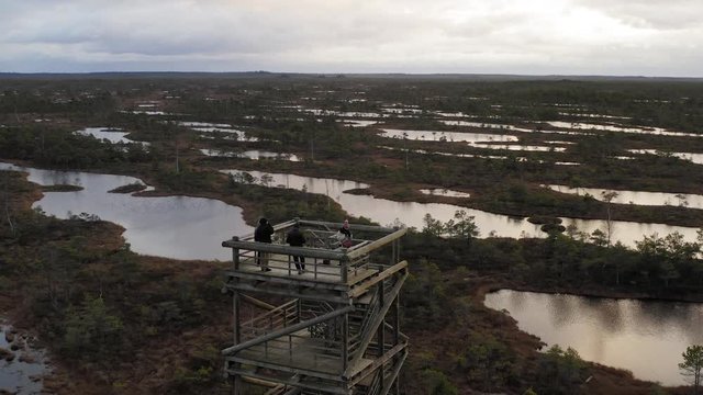 People Standing On Top Of Observation Tower Watching Around The Amazing View Of Swamp Lakes In Latvia - Wide Shot