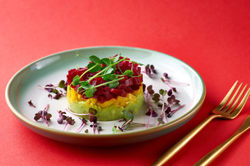 Fresh Tartar tricolor from avocado, mango and beet, selective focus