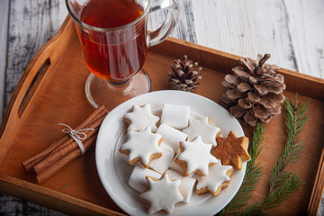 Christmas hot drink - mulled wine, cinnamon stick, star anise and festive Christmas gingerbread cookies over rustic wooden background with copy space, top view