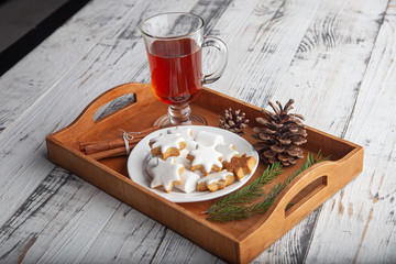 Christmas hot drink - mulled wine, cinnamon stick, star anise and festive Christmas gingerbread cookies over rustic wooden background with copy space, top view