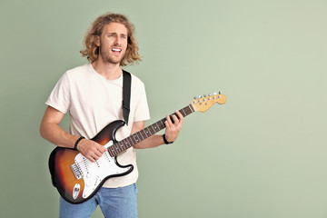 Obraz premium Man playing guitar on color background