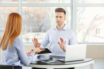 Bank manager working with displeased man in office