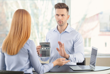 Bank manager working with displeased man in office