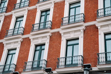 Fototapeta na wymiar Beautiful building with red facade and balconies in Madrid Spain