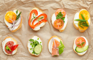 Sandwiches with tasty cream cheese on parchment