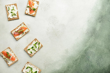 Sandwiches with tasty cream cheese on light background