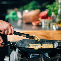 Chef's Hand Frying Sliced Tofu Cheese in Vegan Restaurant