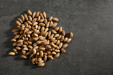 Directly above heap of Pistachios on the gray stone texture with copy space