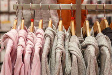 Multicolored hoodies on a hanger in store sportswear side view.