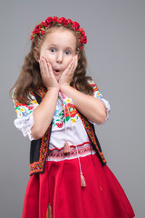 Happy smiling little girl in national Ukrainian folk costume on gray background