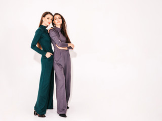 Two young beautiful brunette girls in nice trendy summer suit clothes.Sexy carefree women posing...