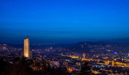 Fototapeta premium Germany, Stuttgart, Blue night sky over skyline of houses of stuttgart city from above in winter season illuminated by night