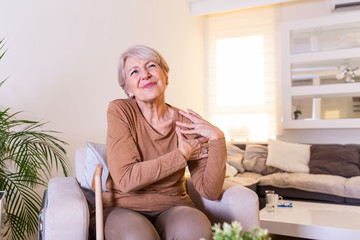 Elderly woman massaging the shoulder easing the aches. Joint pain concept. Senior old lady...
