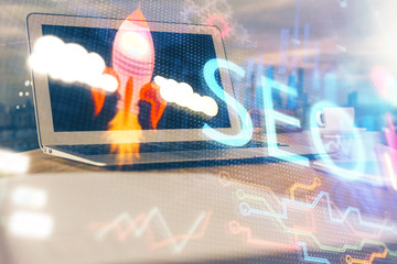Multi exposure of table with computer and seo drawing hologram. Search optimization concept.