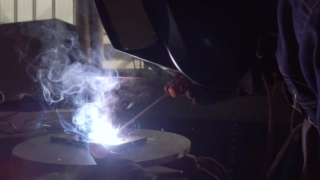 Ingegnere aerospaziale sta saldando un componente per l'aereo dentro la fabbrica. Saldatura a elettrodo rivestito.