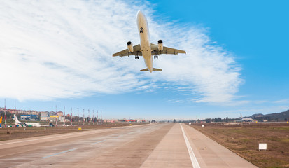 Fototapeta na wymiar A Passenger airplane fly up over take-off runway from airport