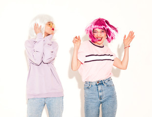Two young sexy smiling hipster girls in wigs and red lips.Beautiful trendy women in summer...