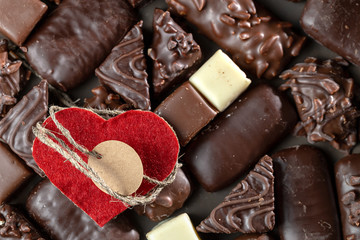Appetizing food background. Assortment of chocolate handmade candy and red heart card for valentines day. Chocolate background. 